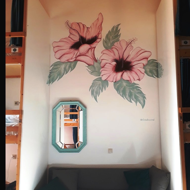 Wandmalerei, auf der zwei rosafarbene Hibiskusblüten zu sehen sind.