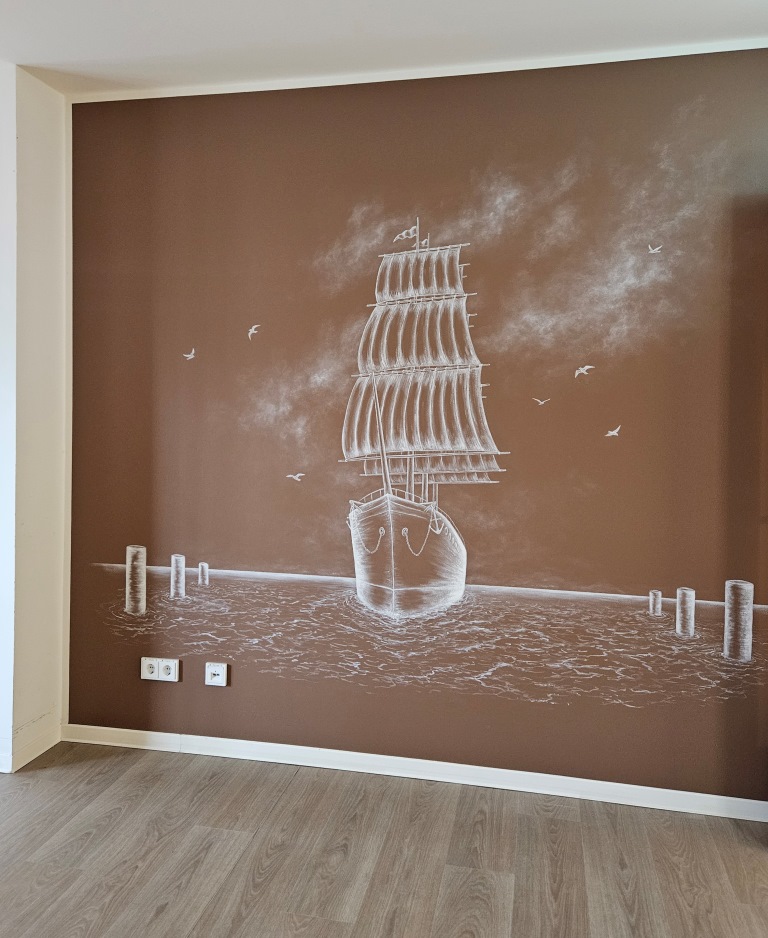 Dunkle Wand mit einer Wandmalerei, auf der ein Segelschiff zu sehen ist.