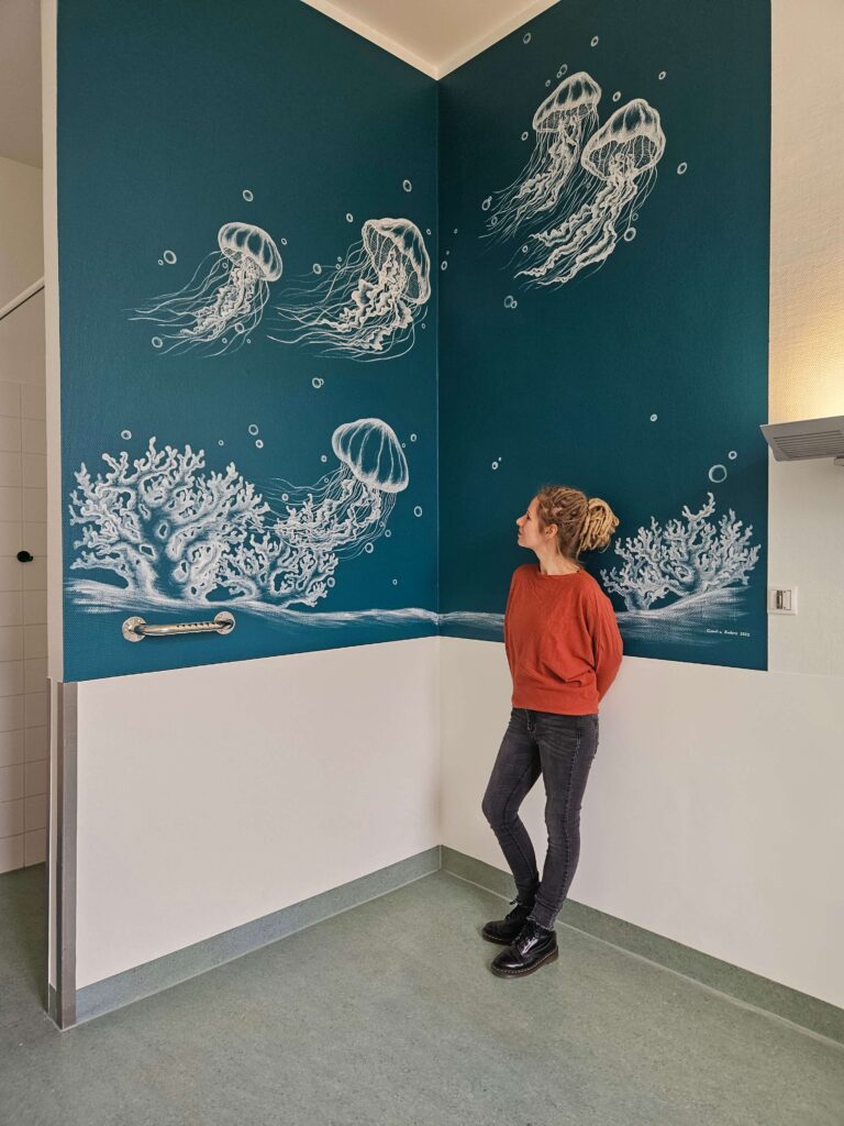 Wandmalerei "Quallen" Petrolfarbene Wand, auf der Quallen und Korallen zu sehen sind.