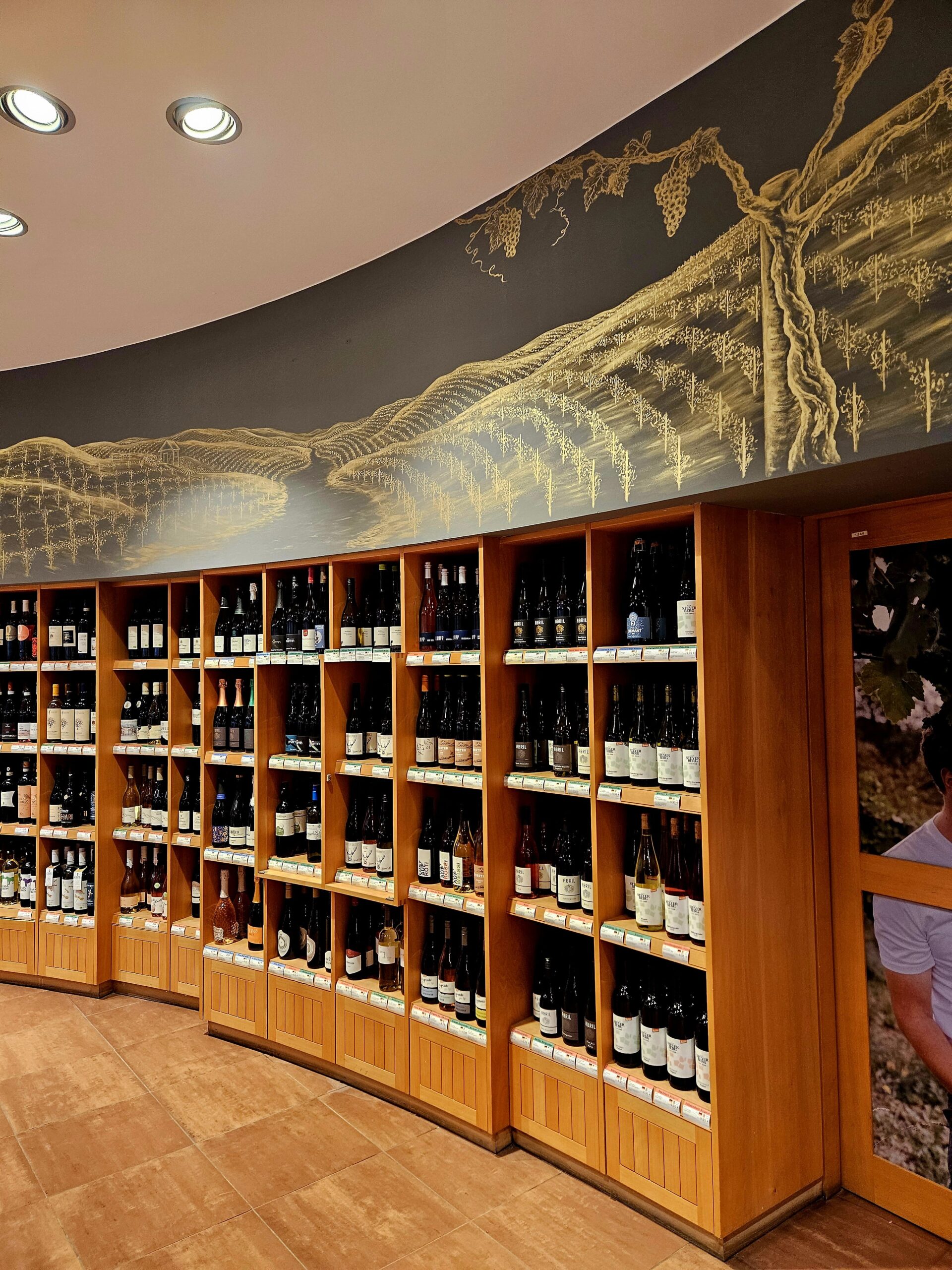 Graue Wand mit einem goldfarbenen Wandgemälde mit Blick auf Weinberge.