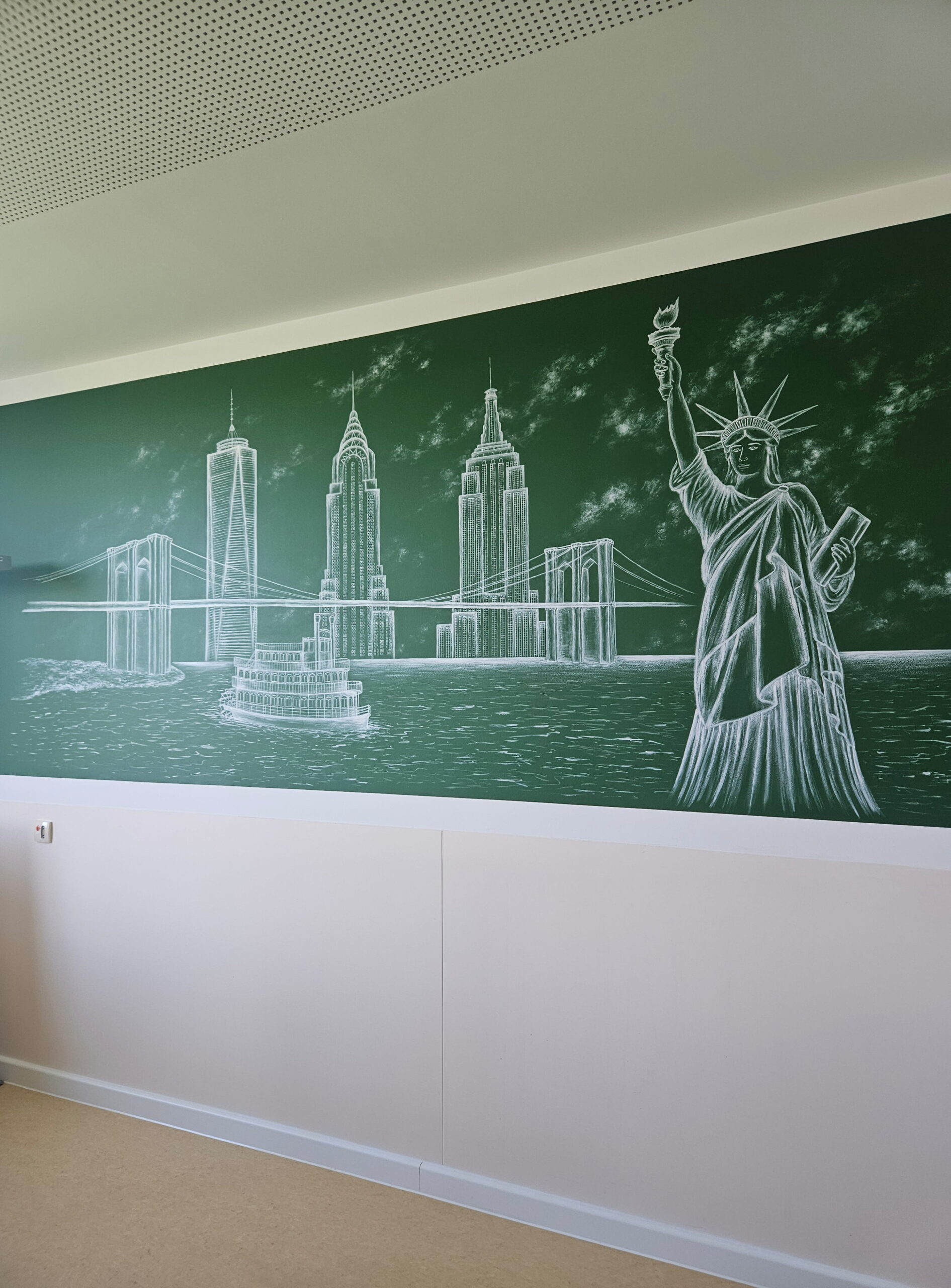 Wandgemälde mit Hauptattraktionen der Stadt New York. Zu sehen sind die Freiheitsstatue sowie die Brooklyn Bridge und der Hudson River mit einem Dampfschiff. Im Hintergrund türmen sich einige Wolkenkratzer auf.
